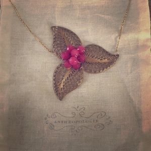 Delicate gold necklace with pink center stone.